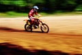 Motocross biker travelling fast in the sunshine Royalty Free Stock Photo