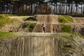 Motocross driver in action accelerating the motorbike takes off and jumps on springboard on the race track. Royalty Free Stock Photo