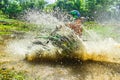 Motocross,enduro rides through the mud with big splash,driver splashing mud on wet and muddy terrain,