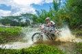 Motocross,enduro rides through the mud with big splash,driver splashing mud on wet and muddy terrain,