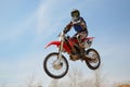 Motocross motorbike racer performs a jump