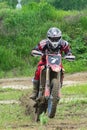 Motocross. A motorcyclist on one wheel rushes along a dirt road, dirt flies from under the wheels.