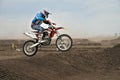 The motocross racer jumps by motorcycle