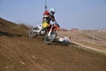 Motocross racer on a motorcycle the turns on a mountain slope