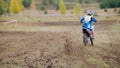 Motocross racer start riding his dirt Cross MX bike - rear view Royalty Free Stock Photo