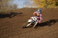 Motocross racer turns with large slope Royalty Free Stock Photo