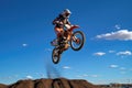 a motocross rider mid-jump against a clear blue sky Royalty Free Stock Photo