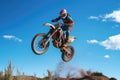 a motocross rider in mid-jump against a clear blue sky Royalty Free Stock Photo