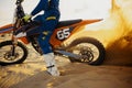 Motocross rider skidding wheel raising sand dust