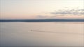 Motor boat at dawn view from a height. Morning landscape. View from the height. A lonely boat floats in the pink water against the