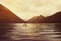 motor boat floats on the mountain'isere departing into the sunset.