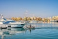 Motor boat with four men among luxury yachts in the marina