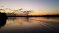 The motor boat moving fast against the beautiful blue-orange sunset. Footage. Evening sun reflected in calm water Royalty Free Stock Photo