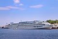 Motor boat next to large passenger white ship on river