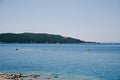 Motor boat pulls a parasailer with a parachute across the sea against the backdrop of mountains Royalty Free Stock Photo