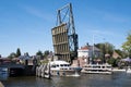 Motor boat sails under an opened steel drawbridge in the Netherlands