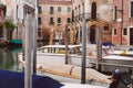 Motor boats are moored up to wooden piles.