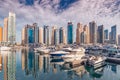 motor boats parking at the port near Dubai Marina Mall with row of high skyscrapers residential buildings and hotels Royalty Free Stock Photo