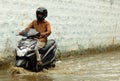 Motor Cyclist ride in rain water flooded road
