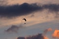 Motor hang glider against the background of a colorful sky with clouds and birds at sunset