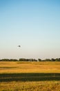 Motor hang glider with passengers flying over aerodrome in clear blue sky Royalty Free Stock Photo