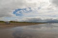 Motor home driving along the endless sandy beach at inch Strand in Dingle bay at low tide