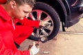 Motor mechanic checking the air pressure of a tyre Royalty Free Stock Photo