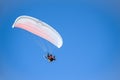 Motor paraplane flying against a rich blue sky