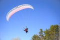 Motor paraplane flying over the forest