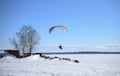 A motor paraplane flying over a frozen lake