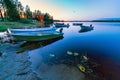 Motor and row boats anchored on the calm summer lake, sunset time, boats reflected in the water. sunset and electrical light Royalty Free Stock Photo