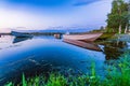 Motor and row boats anchored on the calm summer lake, sunset time, boats reflected in the water. Northern Sweden Royalty Free Stock Photo