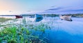 Motor and row boats anchored on the calm summer lake, sunset time, boats reflected in the water. Stocksjo Lake, close to Umea city Royalty Free Stock Photo