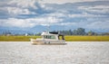 Motor ship at sunset sails on river. Powerboat on a water in overcast day