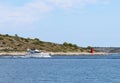 Motor yacht running along the blue sea along the shore. Adriatic sea of Mediterranean area. Dalmatian region of Croatian country. Royalty Free Stock Photo