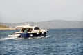Motor yacht running along the blue sea along the shore. Adriatic sea of Mediterranean area. Dalmatian region of Croatian country. Royalty Free Stock Photo