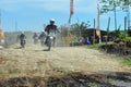 A motorbike cross racer is practicing on a dusty track