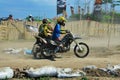 A motorbike cross racer is practicing on a dusty track