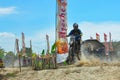 A motorbike cross racer is practicing on a dusty track