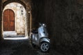 Motorbike in dark arch of Rhodes town with old wooden door on a background. Rhodes island, Greece Royalty Free Stock Photo