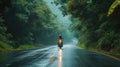 a motorbike driver navigating through the rain on a densely tree-lined road, the shimmering raindrops and lush Royalty Free Stock Photo