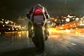Motorbike drives through night city