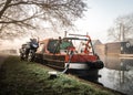 Motorbike parked next to narrow canal house boat side of river as sun rises. Peaceful and idyllic. Royalty Free Stock Photo