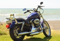 Motorbike parked on the ocean beach seaside shore line of New Zealand
