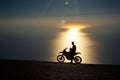 Motorbike rider resting in the sunset