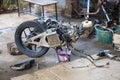 Motorbike In the shop, the motorbike is being disassembled, draining the automatic motorbike oil. Change the oil in a small tank,