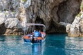 Motorboat entering a cave at coast Taormina, Sicily, Italy