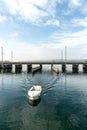 Motorboat with female captain passes from the lower to the upper Lake Zurich through the passage on the Seedamm bridge near Rappe