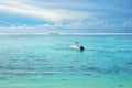 Motorboat sailing towards the horizon in the blue sea against the cloudy blue sky Royalty Free Stock Photo