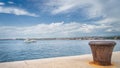 Motorboat sailing in Zadar bay and single, old and rusty mooring bollard